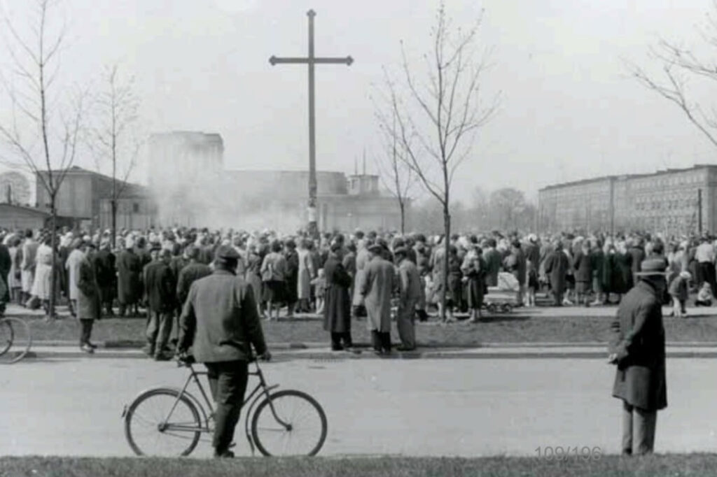Zdjecie archiwalne. Ludzie zgromadzeni wokół krzyża.